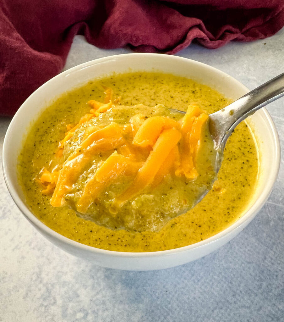 a spoonful of Crockpot broccoli cheese soup with cheddar
