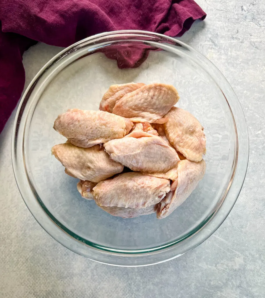 raw split chicken wings in a glass bowl