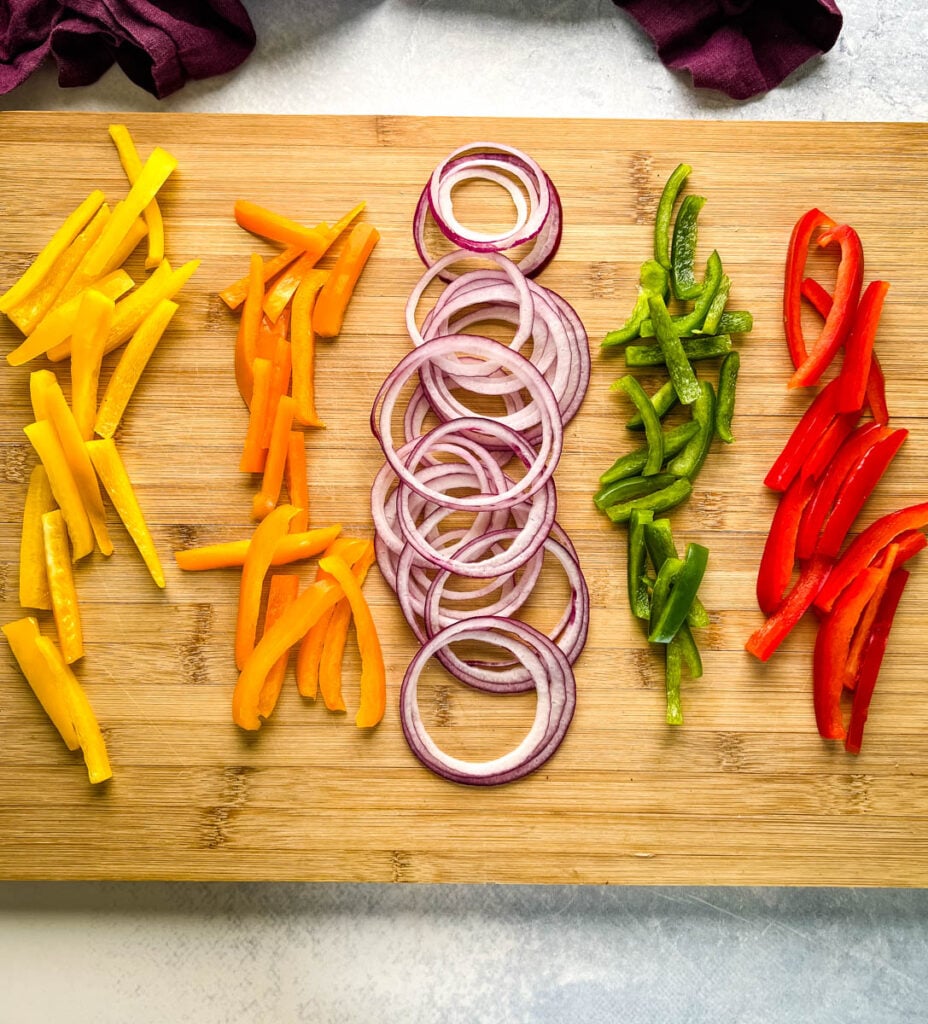 sliced bell peppers and onions on a cutting board