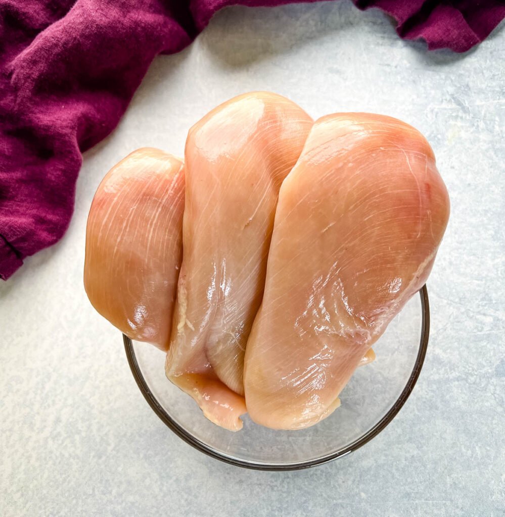 raw chicken breasts in a glass bowl