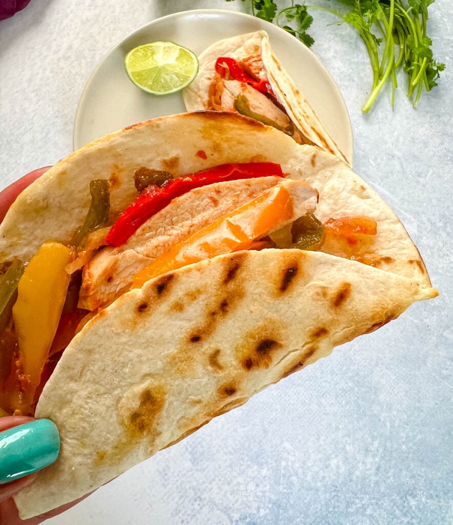 person holding slow cooker Crockpot chicken fajita