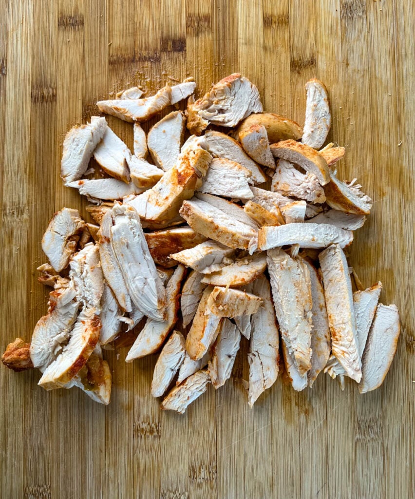 sliced chicken breasts on a bamboo cutting board