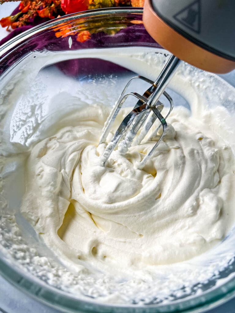 hand mixer in a glass bowl with sugar free whipped cream