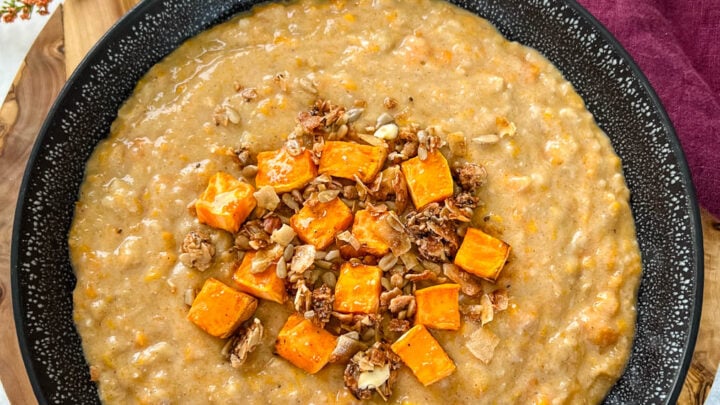 sweet potato oatmeal in a black bowl topped with granola and honey