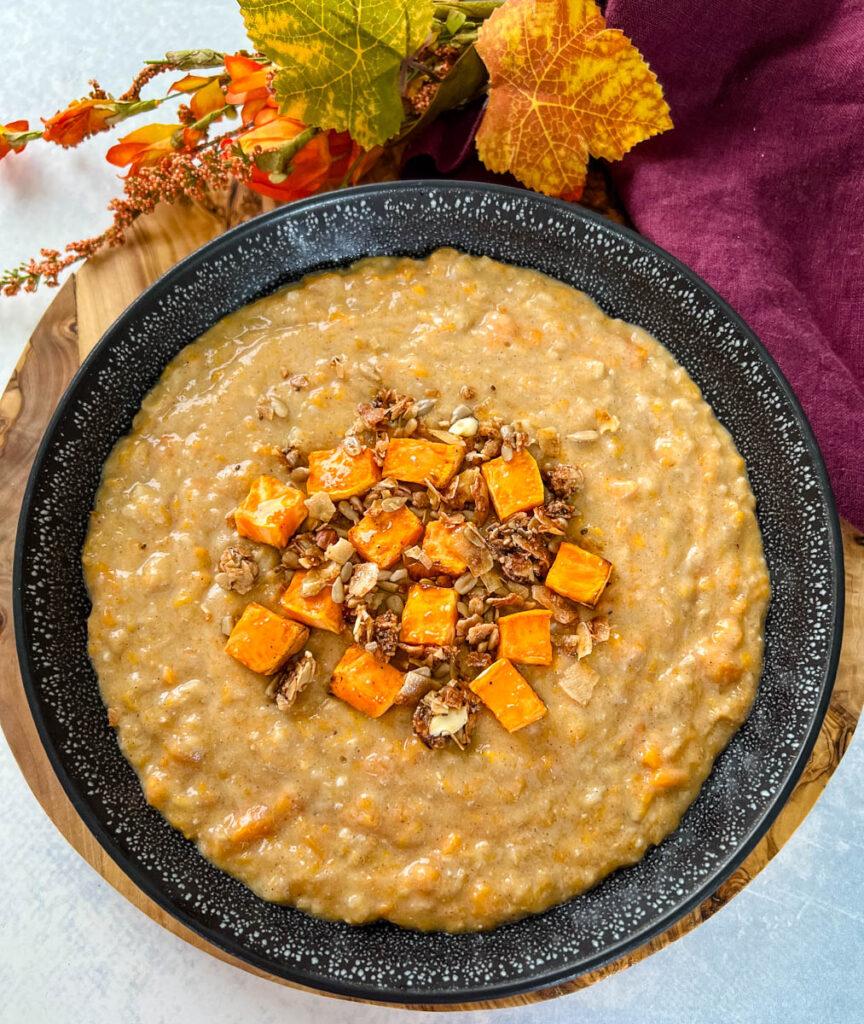 sweet potato oatmeal in a black bowl topped with granola and honey