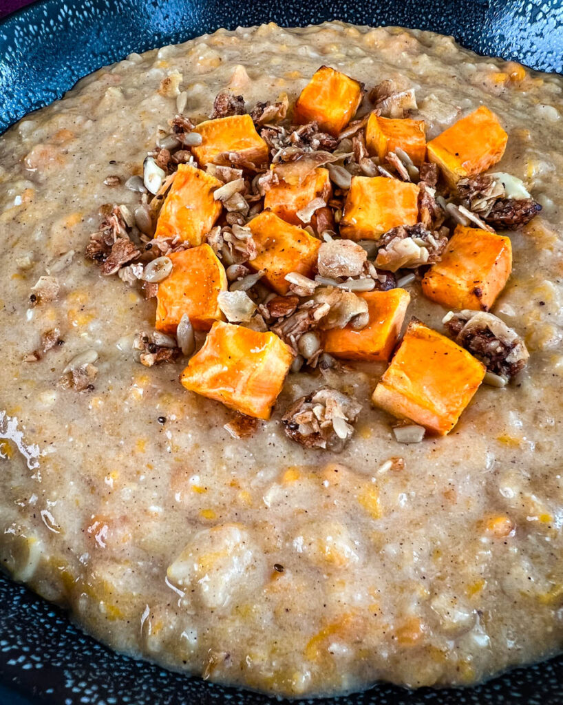 sweet potato oatmeal in a black bowl topped with granola and honey