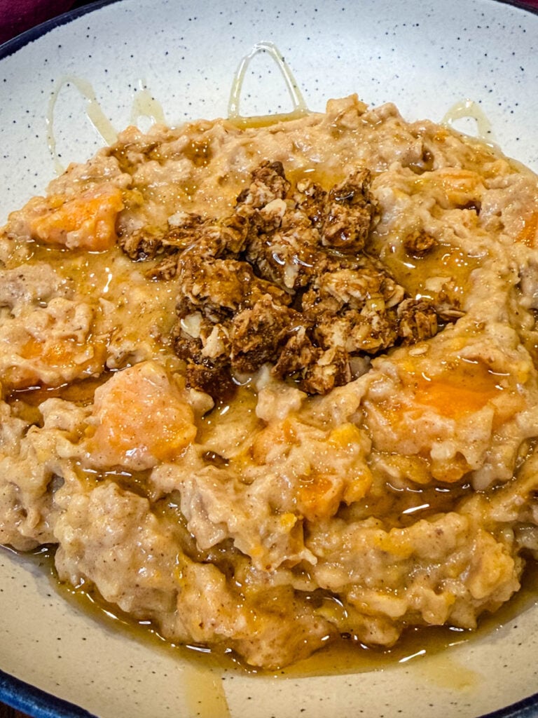 sweet potato oatmeal in a white bowl drizzled with honey and granola