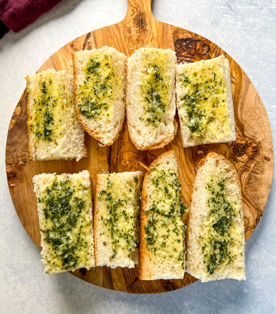 pan de ajo en rodajas en una tabla para cortar