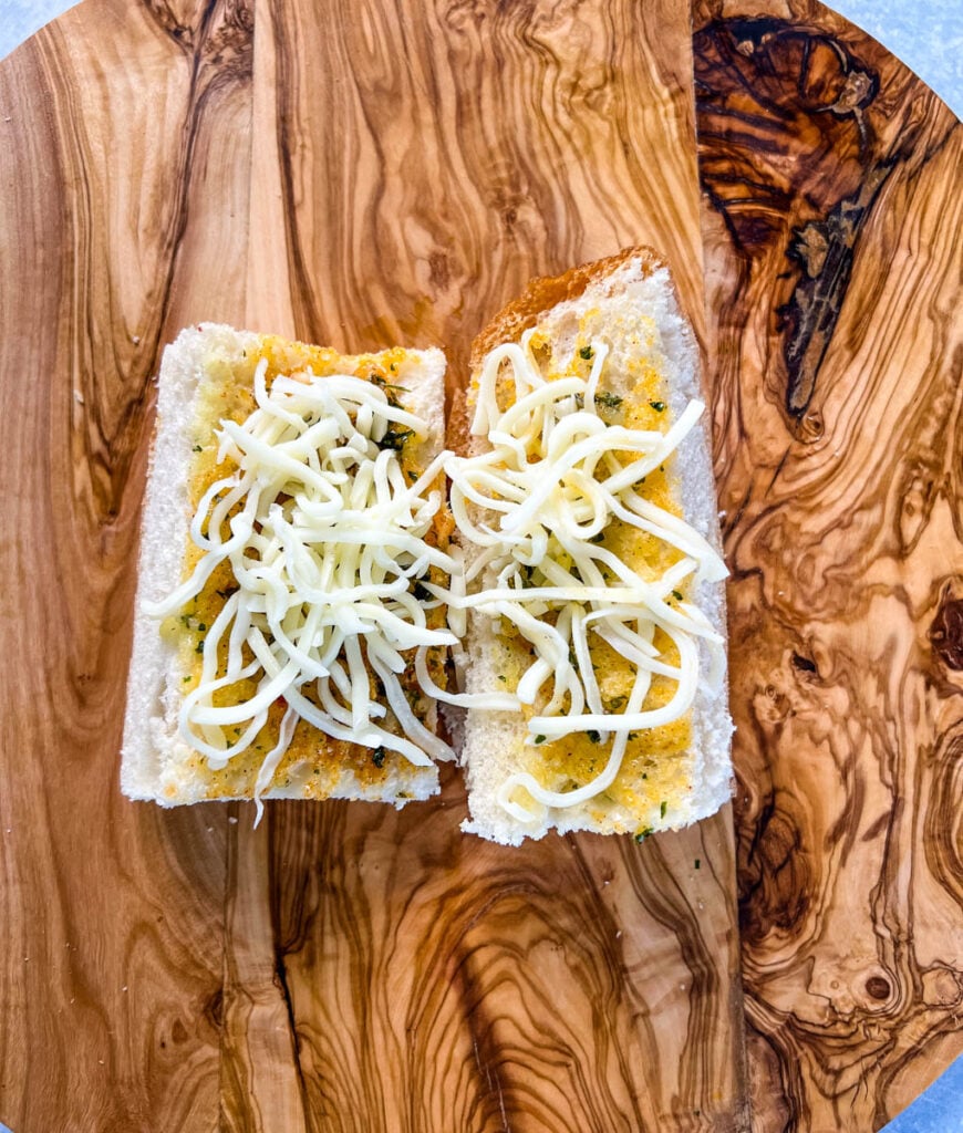 garlic bread with cheese on a cutting board