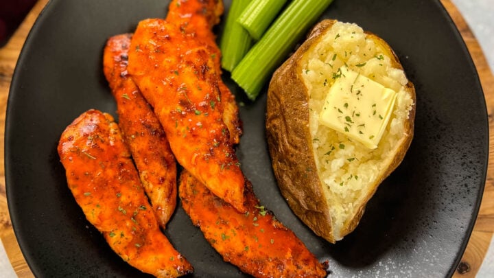 buffalo chicken tenders on a plate with celery, and a baked potato
