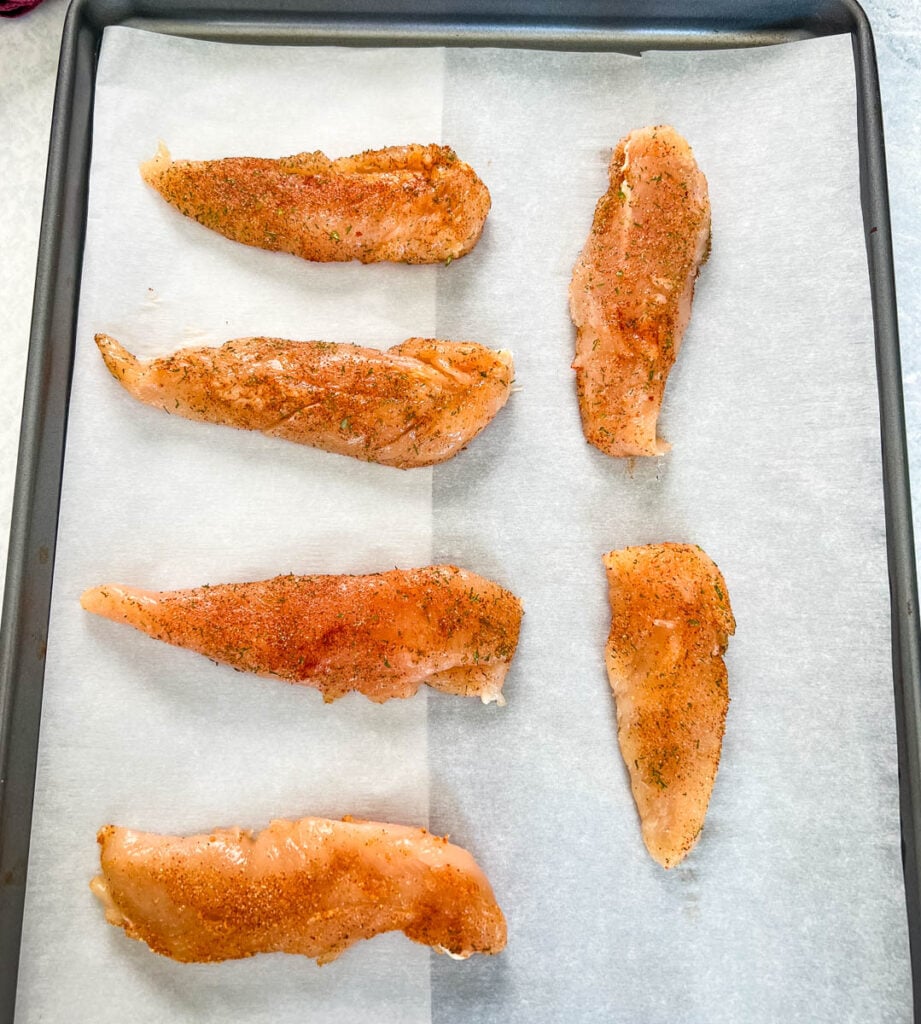 raw chicken tenders on a sheet pan