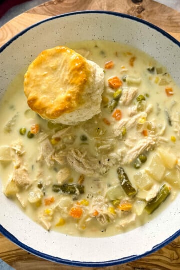 slow cooker crockpot chicken pot pie in a bowl with a biscuit