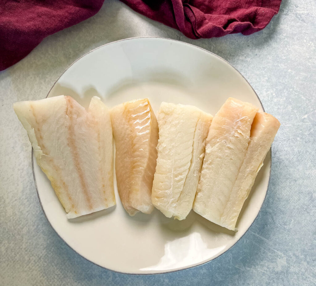 raw cod fillets on a plate