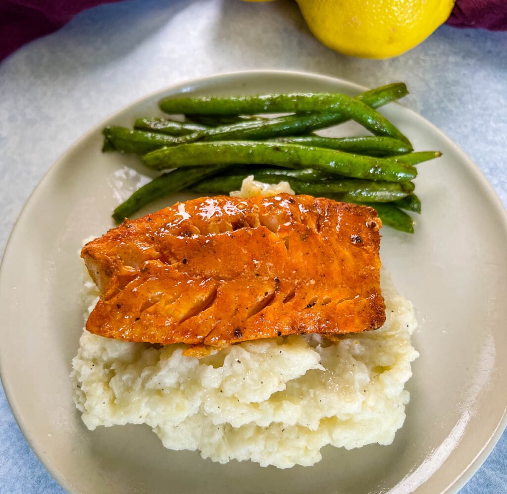 lemon pepper fish, mashed potatoes, and green beans on a plate