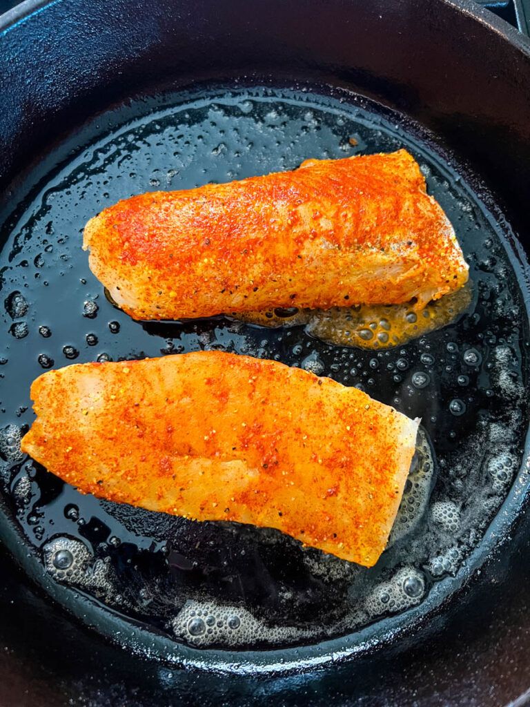 seasoned fish in a cast iron skillet