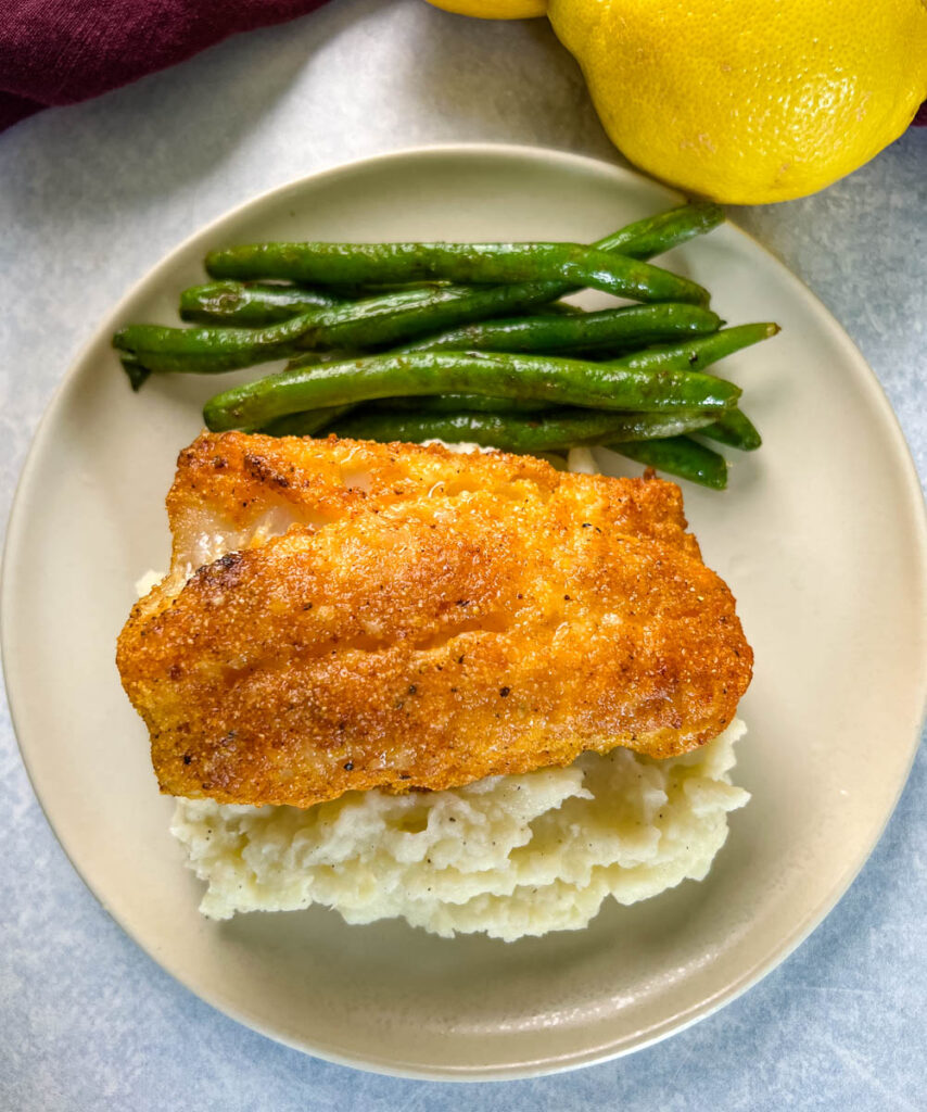 lemon pepper fish, mashed potatoes, and green beans on a plate