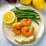 lemon pepper shrimp, mashed potatoes, and green beans on a plate