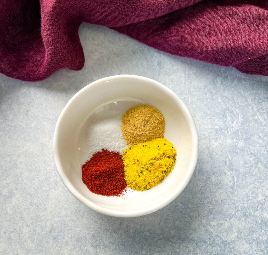 lemon pepper seasoning, smoked paprika, garlic powder, and salt in a white bowl