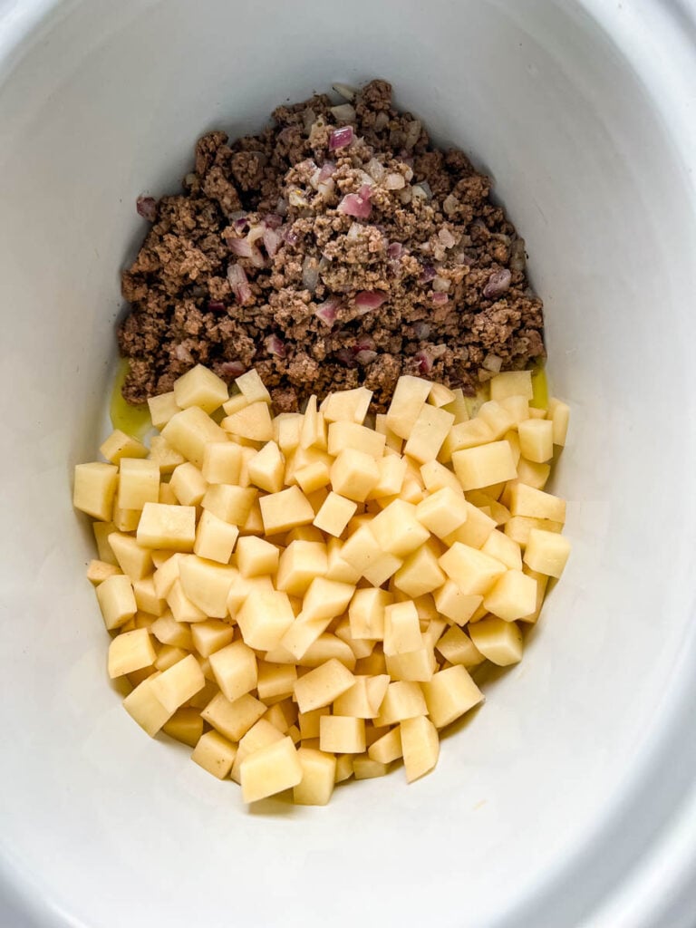 cooked ground beef and diced potatoes in a Crockpot slow cooker