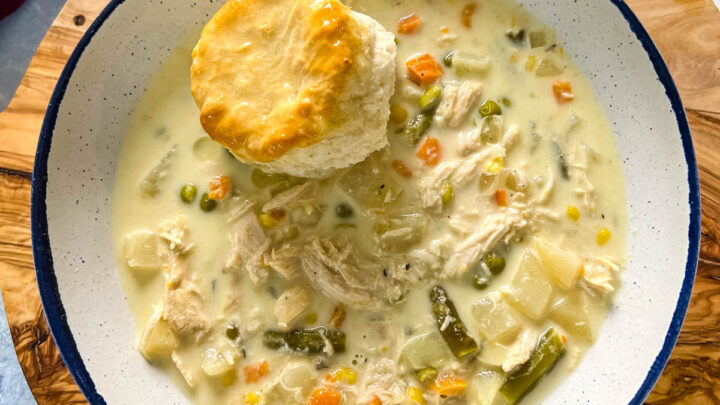 slow cooker crockpot chicken pot pie in a bowl with a biscuit