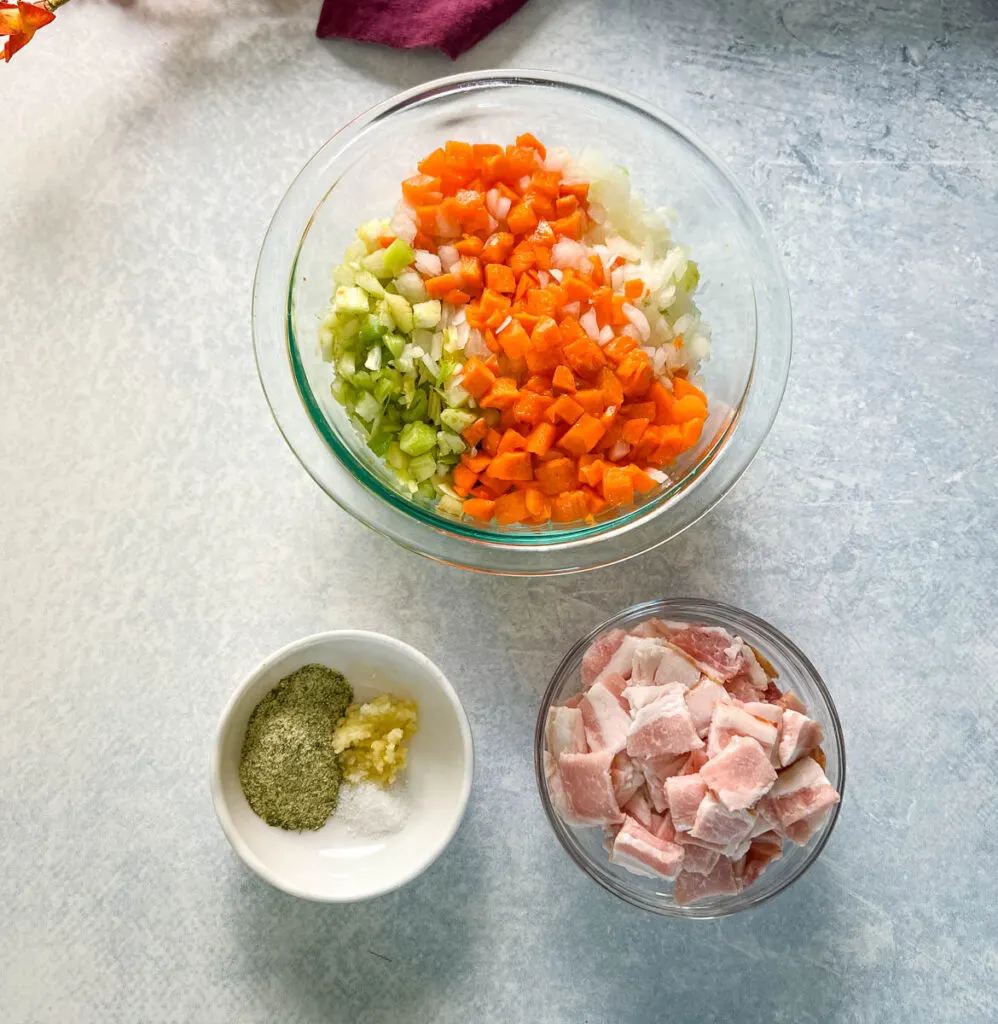 chopped carrots, celery, onions, bacon, and spices in separate bowls