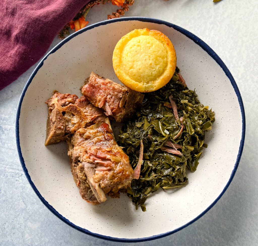 slow cooker Crockpot neck bones in a bowl with collard greens and cornbead