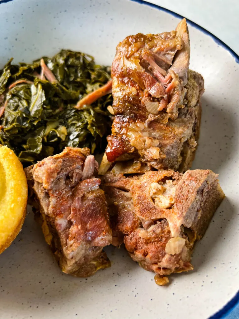 slow cooker Crockpot neck bones in a bowl with collard greens and cornbead