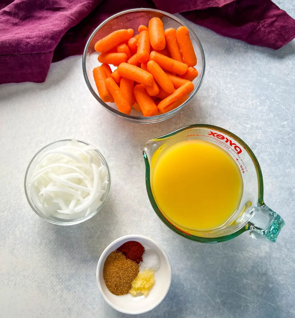 fresh carrots, onions, broth, and spices in separate bowls