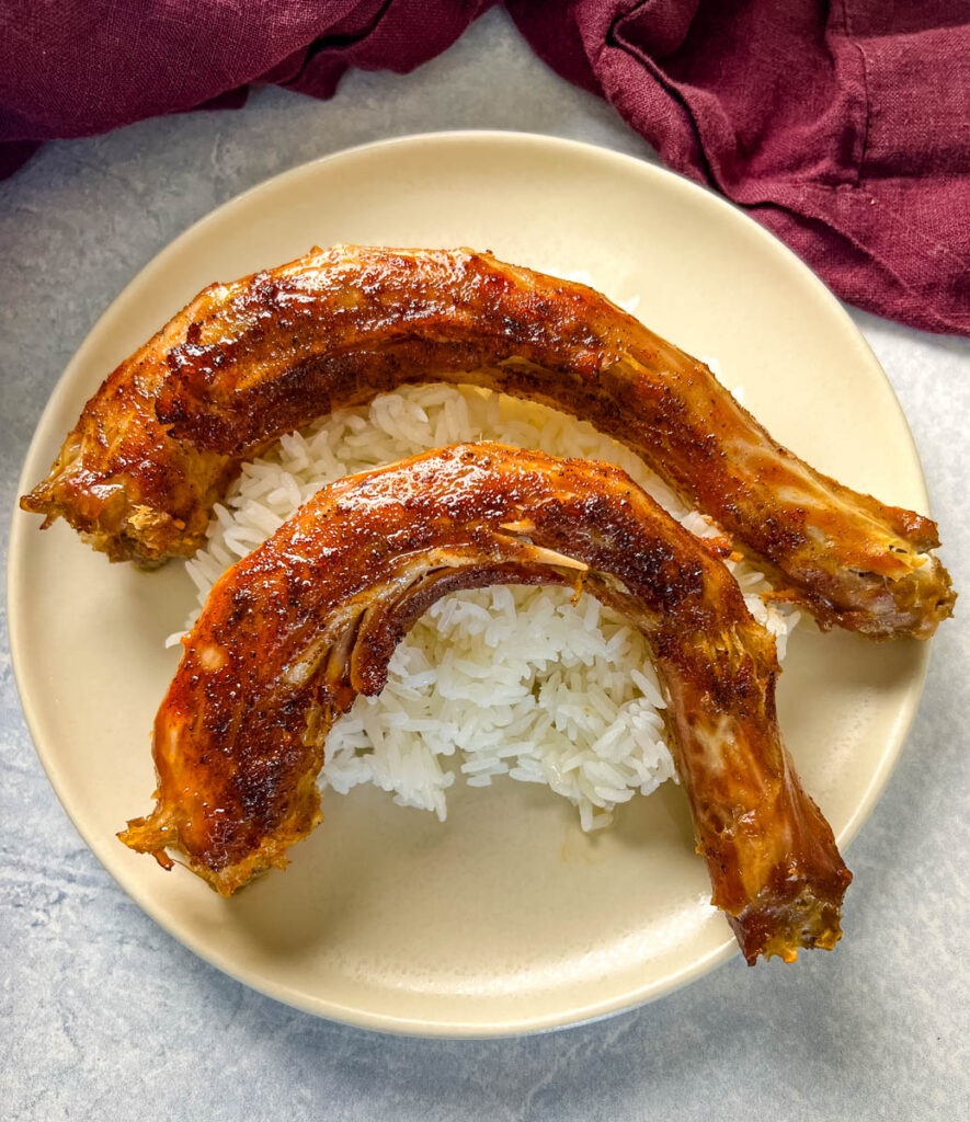 slow cooker turkey necks on a plate with white rice