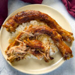 slow cooker turkey necks on a plate with white rice