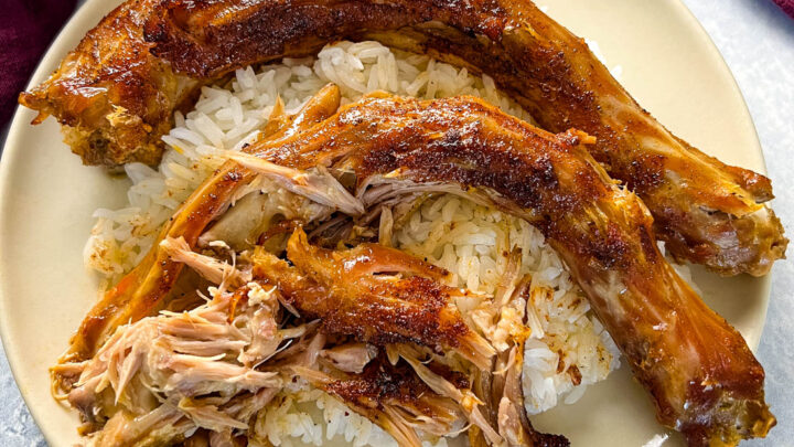 slow cooker turkey necks on a plate with white rice