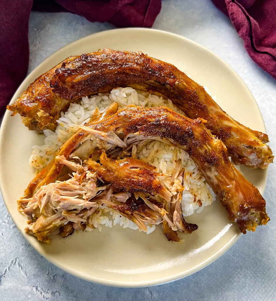 slow cooker turkey necks on a plate with white rice