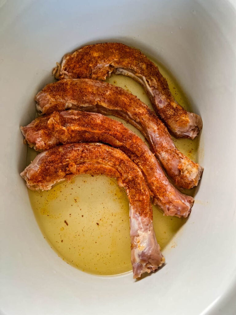 raw, seasoned turkey necks in a Crockpot slow cooker