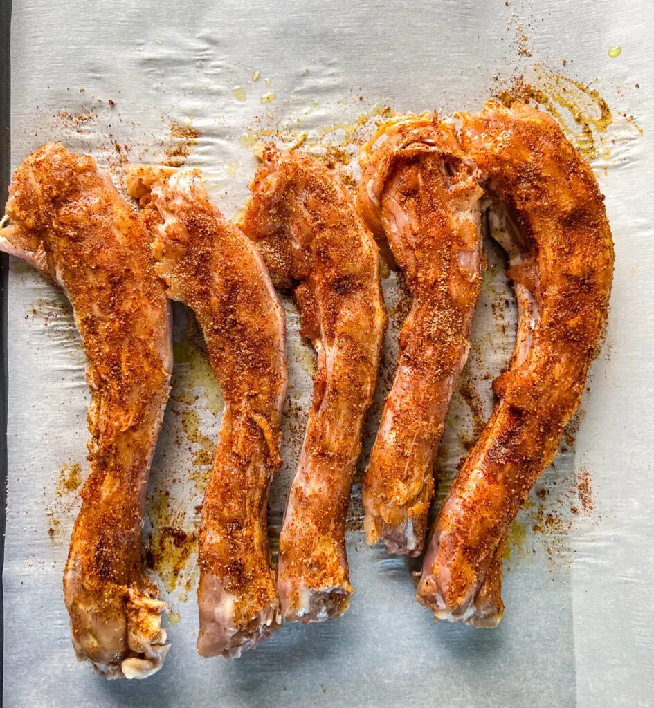 seasoned raw turkey necks on parchment paper