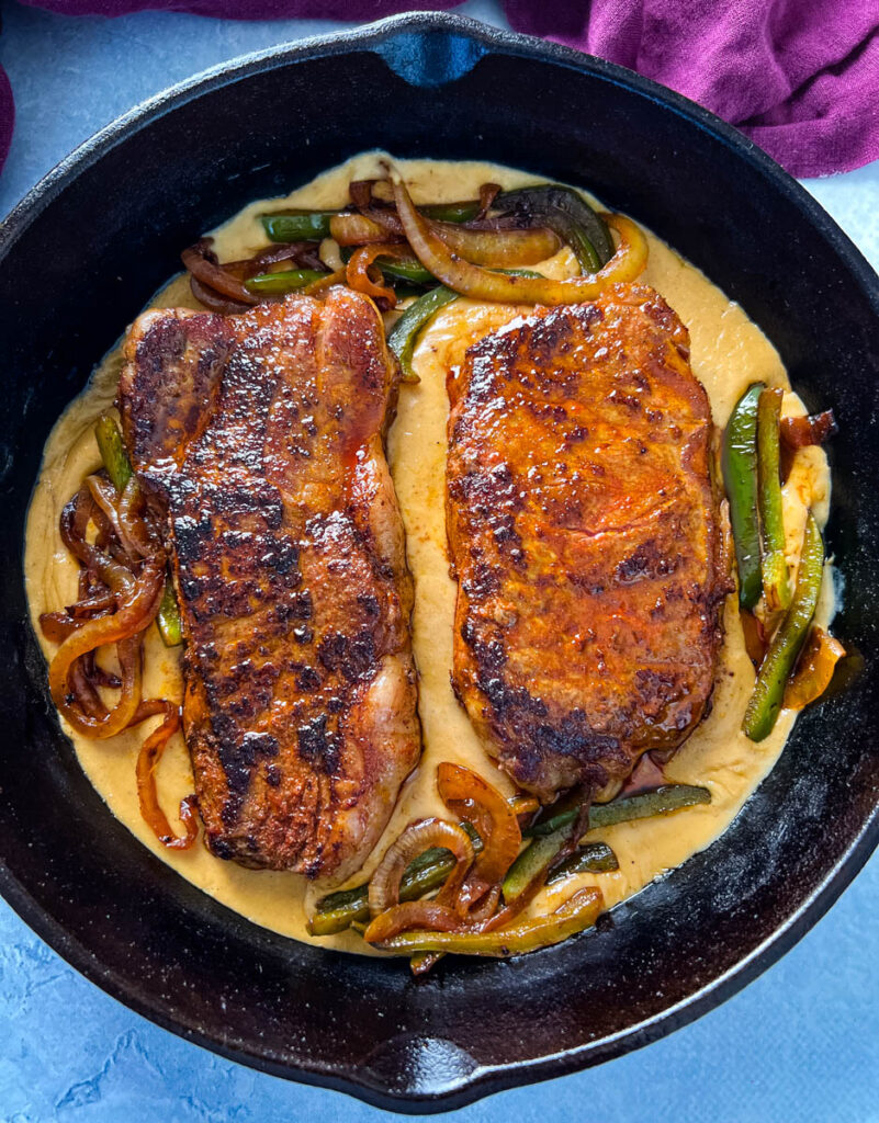 smothered steak with gravy in a cast iron skillet