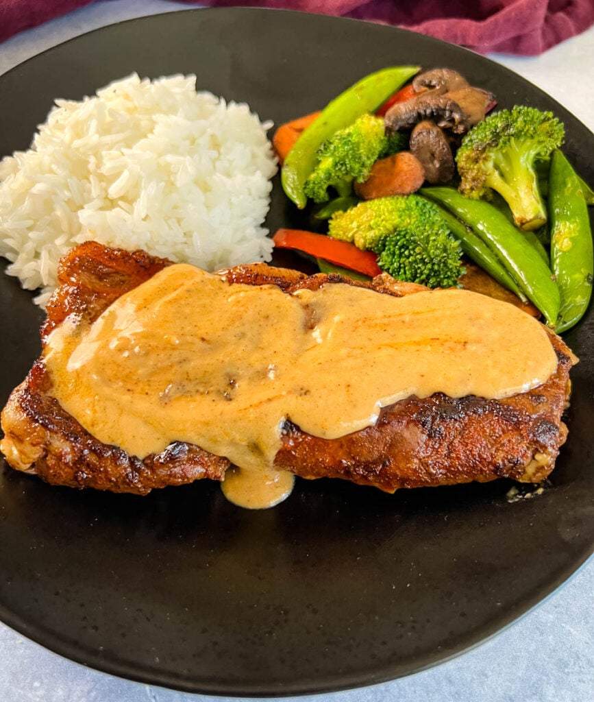 smothered steak with gravy and rice and vegetables