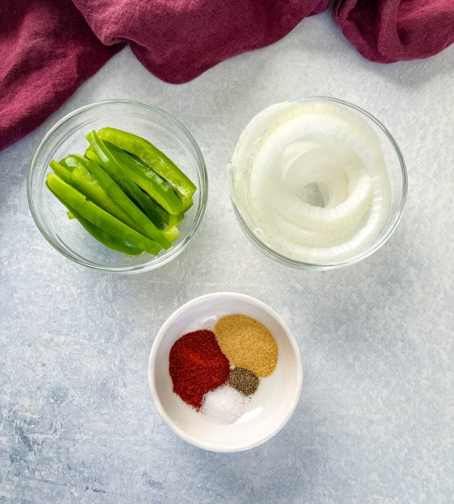 green peppers, onions, and spices in white bowls