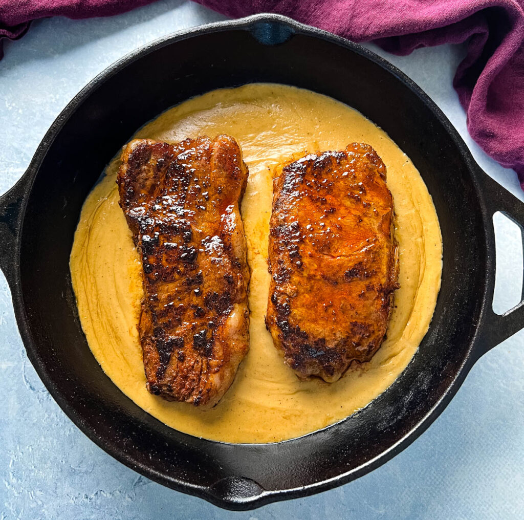 smothered steak with gravy in a cast iron skillet