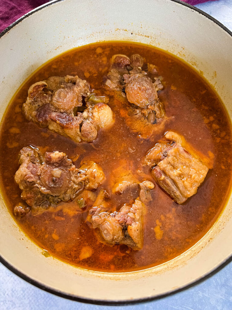 cooked oxtail in a pot with broth