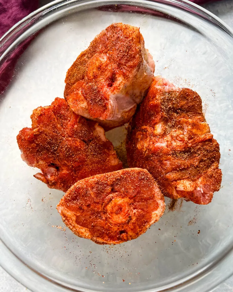 raw, seasoned oxtail in a glass bowl