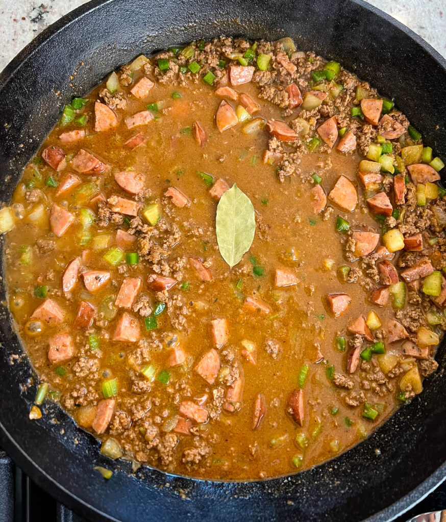 ground beef, sausage, and Holy trinity vegetables in a cast iron skillet