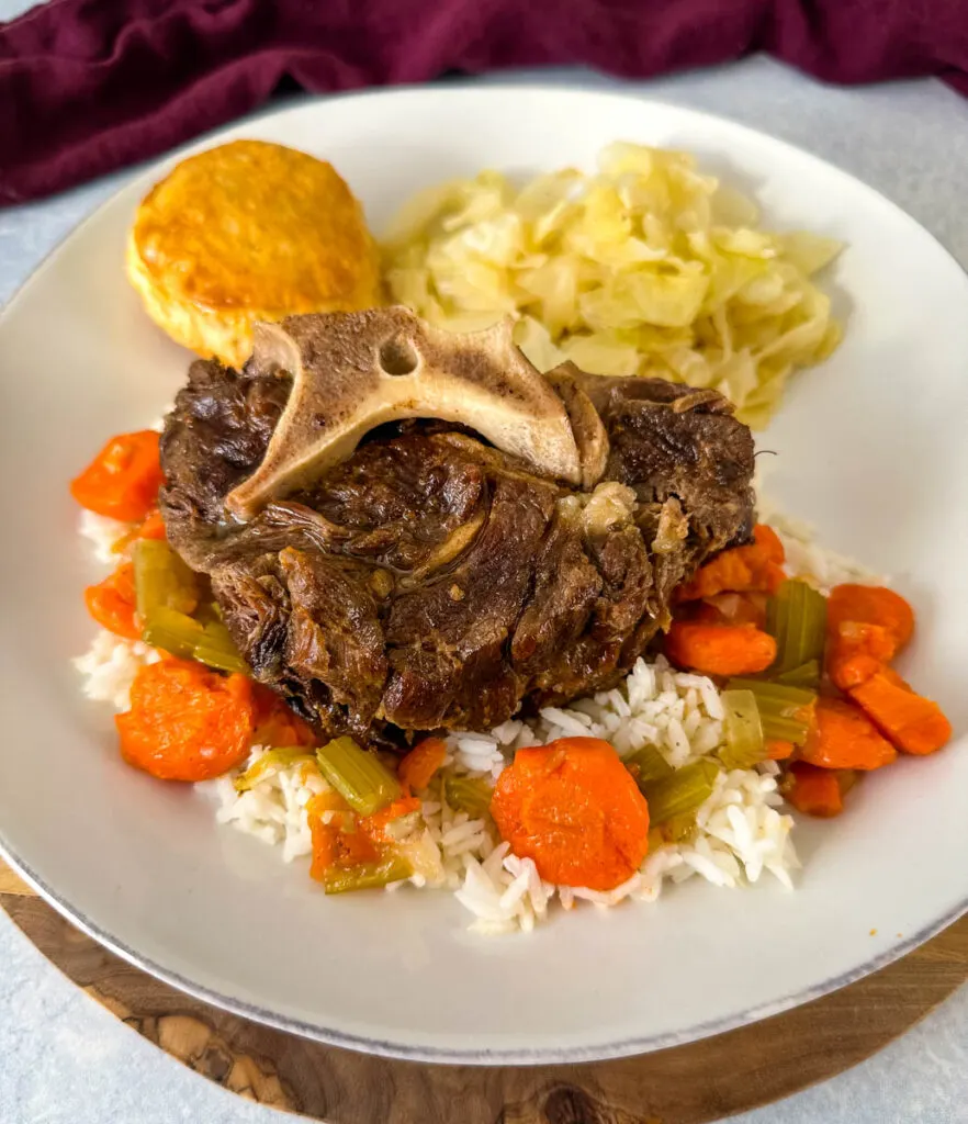 beef neck bones with cabbage, rice, and carrots on a plate