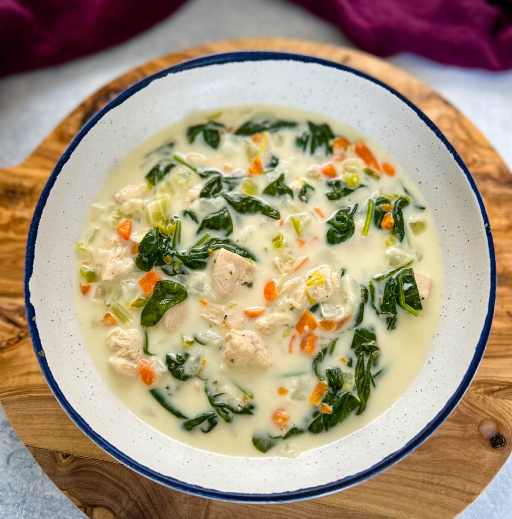 chicken florentine soup and spinach in a white bowl