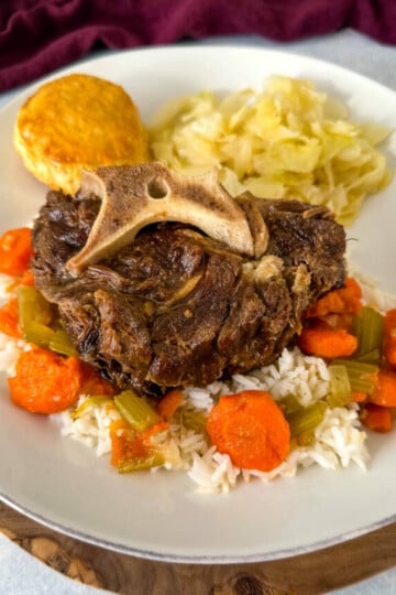 beef neck bones with cabbage, rice, and carrots on a plate