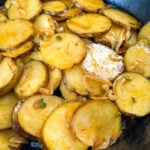 fried potatoes and onions in a cast iron skillet