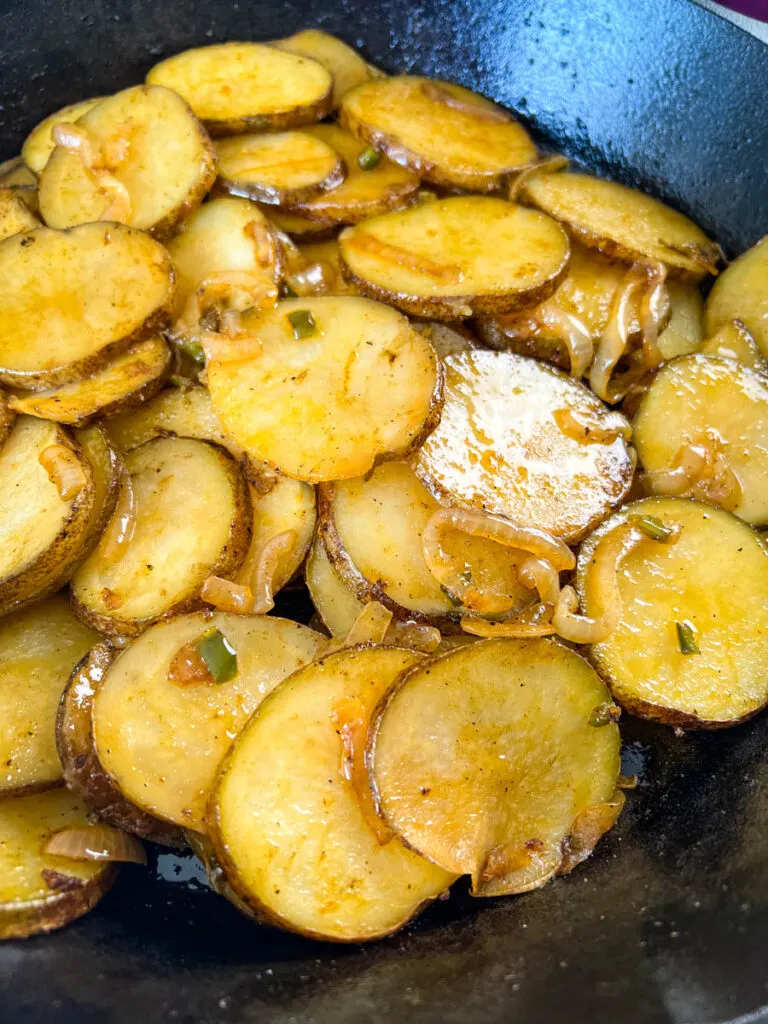 fried potatoes and onions in a cast iron skillet