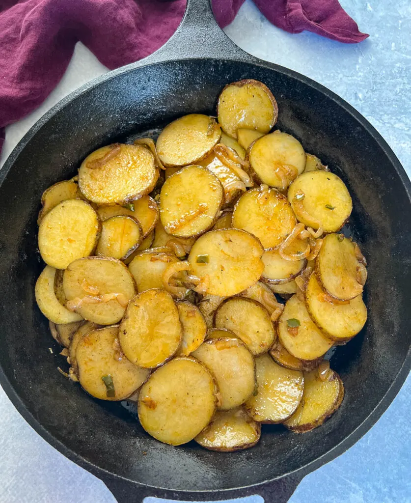 fried potatoes and onions in a cast iron skillet