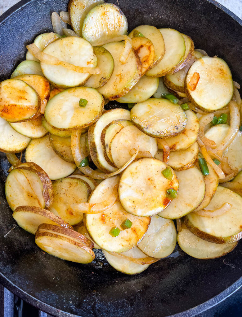 potatoes, onions, and green pepper in a cast iron skillet