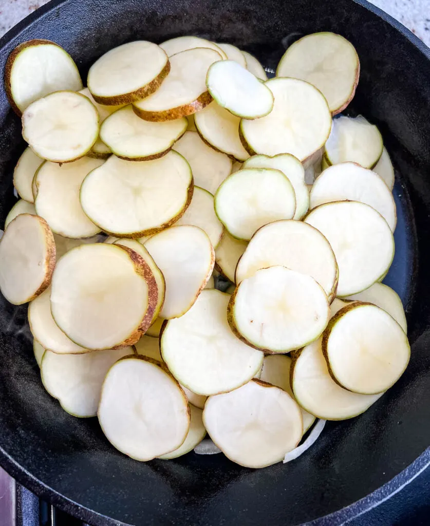 potatoes, onions, and green pepper in a cast iron skillet