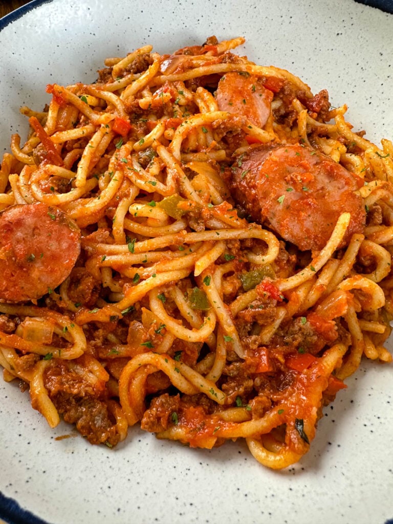 beef and sausage spaghetti in a white bowl